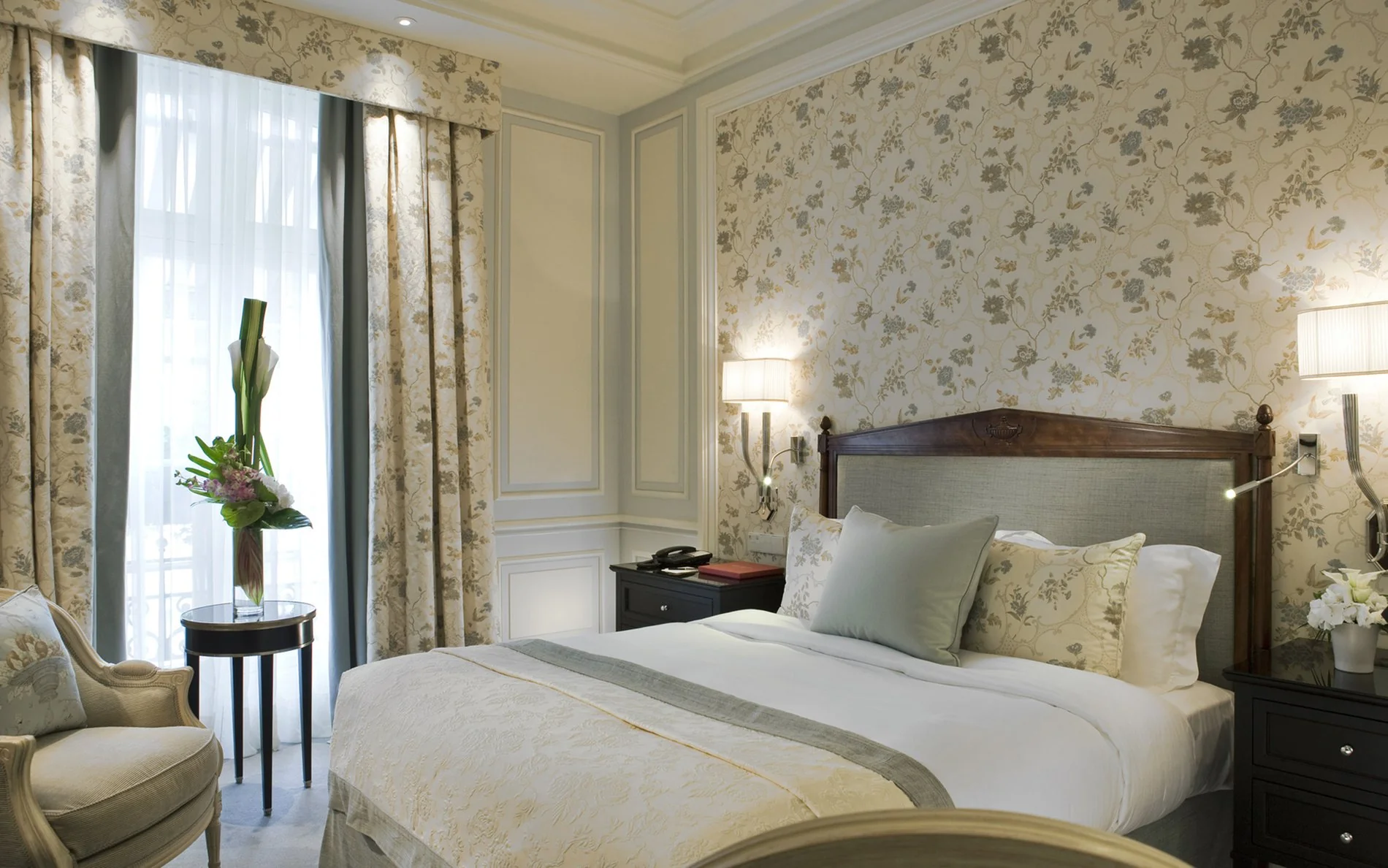 Chambre classique de l’Hôtel San Régis à Paris, décor floral raffiné, lumière naturelle et ambiance chaleureuse.